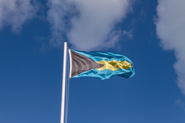 Bahamas Flag Blowing in the Wind Against Bright Blue Sky