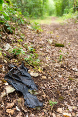 Plastic pollution along a hiking trail. Plastic pollution in a forest, along a path in the countryside. Environmental damage caused by human. Plastic waste on a trail