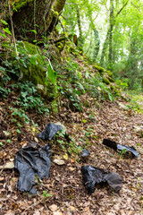 Plastic pollution along a hiking trail. Plastic pollution in a forest, along a path in the countryside. Environmental damage caused by human. Agricultural plastic waste on a trail