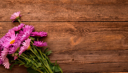 Fototapeta premium Top View Bouquet Lilac Purple Daisies in Corner Wooden Table. Copy space.