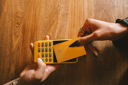 woman paying with card at bar