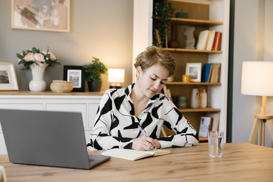 Businesswoman working in office, taking notes 