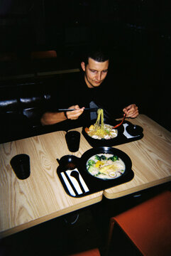 Man Enjoying Dinner at Japanese Restaurant With Ramen Noodles