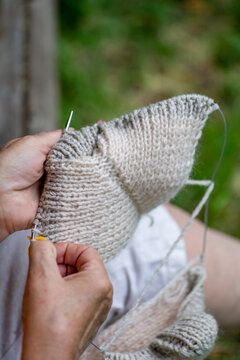 Elderly woman knitting in the garden
