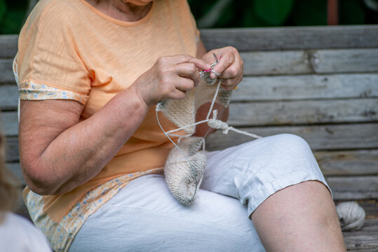 Elderly woman knitting in the garden