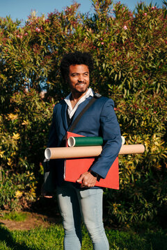 Professional man holding folders and portfolio tubes