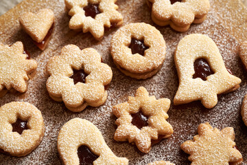 Linzer Christmas cookies dusted with sugar on a wooden board