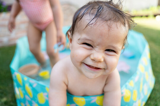 Happy baby enjoying outdoor kiddie pool fun