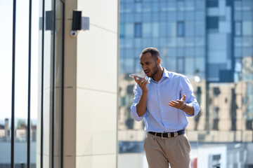 Man wearing formal wear talking on smartphone while walking in city street