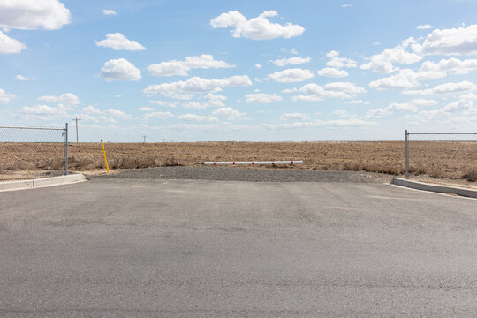 Empty parking lot, farmland in distance