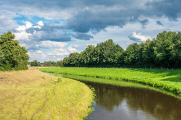 Naklejka premium The Hase river and green surroundings on a sunny day in Löningen, Lower Saxony, Germany