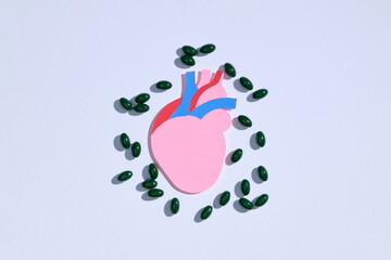 Healthy Heart Concept with Green Pills on White Background