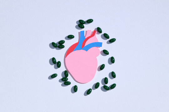 Healthy Heart Concept with Green Pills on White Background