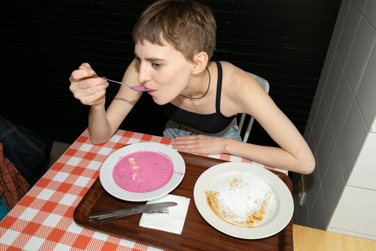 the girl leaned over a plate of soup