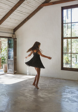 Young woman twirling dancing alone