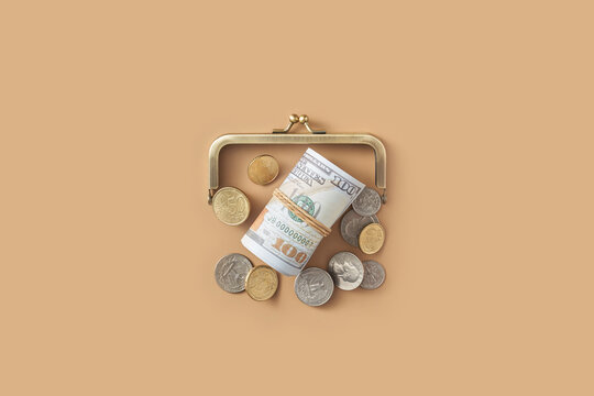 Cash and coins laying under old fashioned wallet closing mechanism