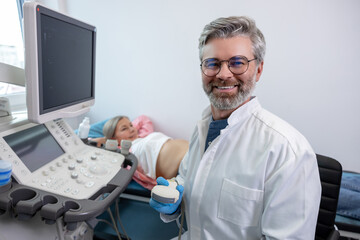 Male doctor looking confident while working with a female patient in clinic