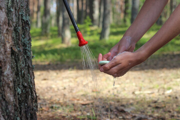 Teen washing hands with soapwhile camping, camp hygiene, camp solar shower bag, camping in Europe,...