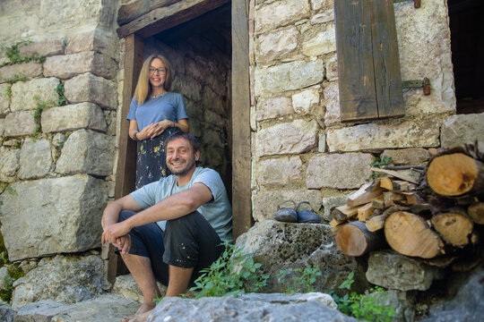 Country couple on the doorstep of an old stone house