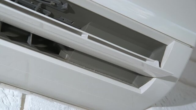 Cooling white device working on wall. A view of working new cooling device hang on the flat wall inside.