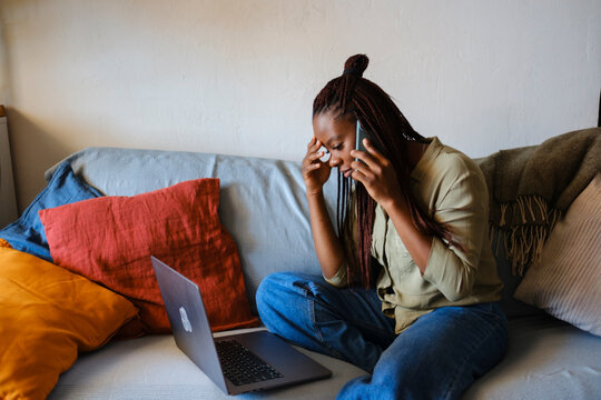 Woman at home living room on phone call looking frustrated