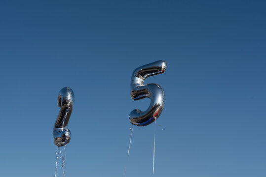 Silver balloons in the shape of numbers 25