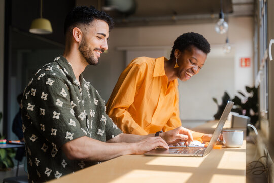 Businesspeople Working Together With Laptop In Modern Workplace