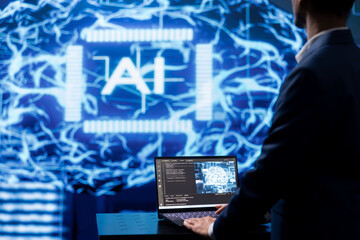 Programmer using AI cognitive computing to extract usable information from complex data on laptop....
