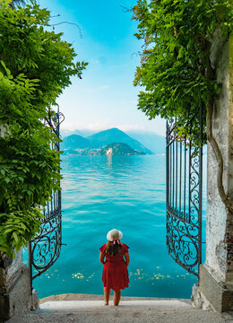 View of Lake Como from the botanical garden of Villa Monastero, Varenna, Italy. Red polka dot dress