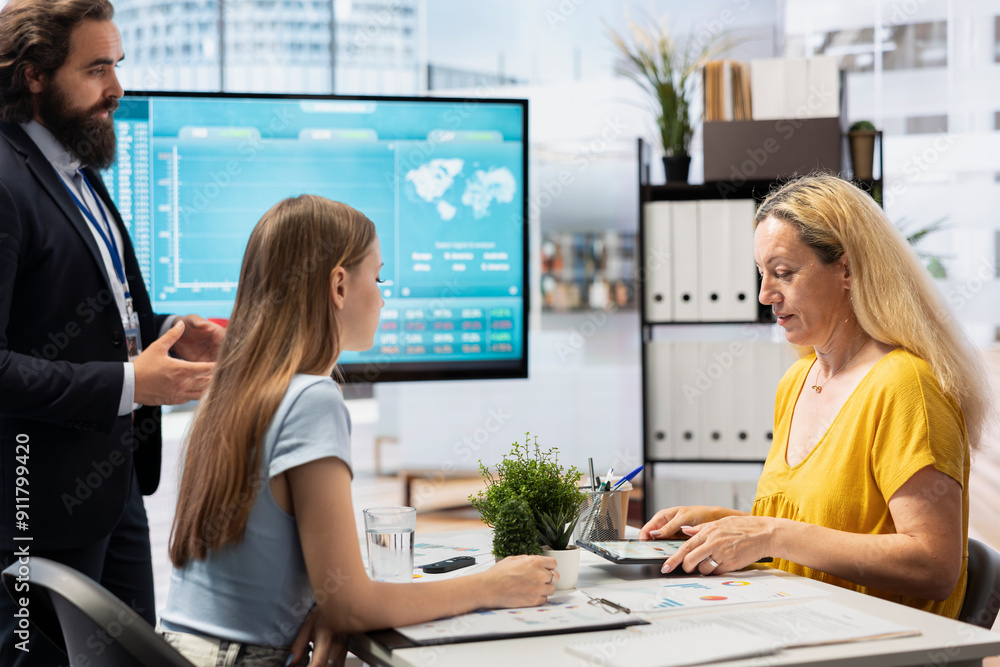 Poster financial adviser presents market analytics to customers using large display, exploring best practic