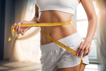 Weight lose concept. Slim young woman use tape measuring