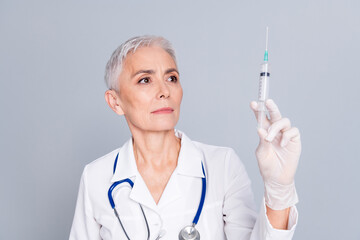 Photo of female doctor woman qualified specialist preparing injection vaccine injection isolated on grey color background
