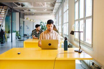 Male Entrepreneur Using Laptop In Modern Workplace