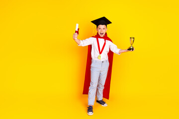 Photo of cheerful happy clever successful boy graduate wear red cape win isolated on yellow color background