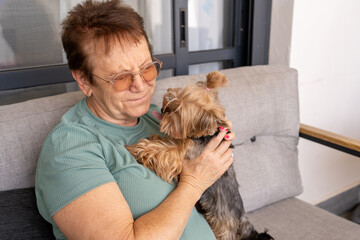 Joyful Senior Squints as Dog Licks Her Face. Pet Therapy at Home.