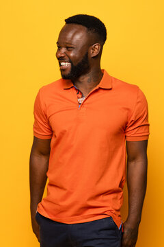 Cheerful black man in orange shirt with bright yellow background