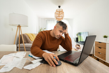 Frustrated man doing accounting work holding his head