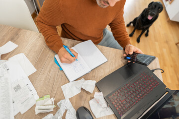 Accountant working using calculator app and taking notes