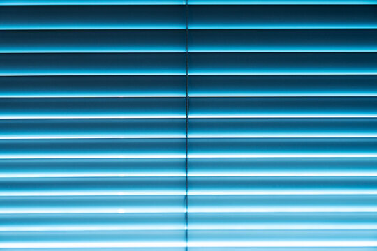 Lights shine in through blinds.