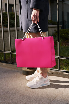 Person Carrying Pink Shopping Bag Outdoors