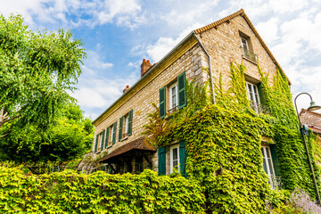 Picturesque facade of a house in Giverny, walls covered with ivy, Normandy region, Fran
