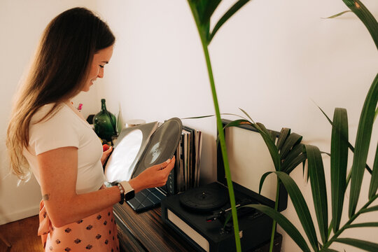 Woman with vinyl record in her hands at home