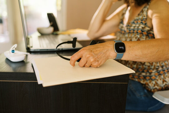 close up of home office worker with wireless headset and smart watch