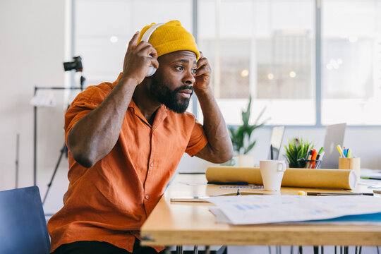 Designer focused on creative tasks while listening to music in office