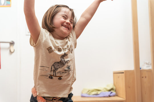 Young Girl Raising Arms and Smiling