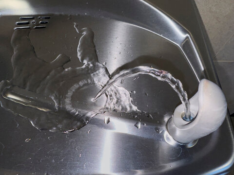 Water fountain bubbler  in use  in basin for thirst 
