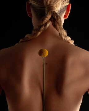 The back of a girl with a flower on the shoulder blades.