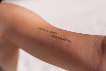 Crop person with tattoo with digits on arm