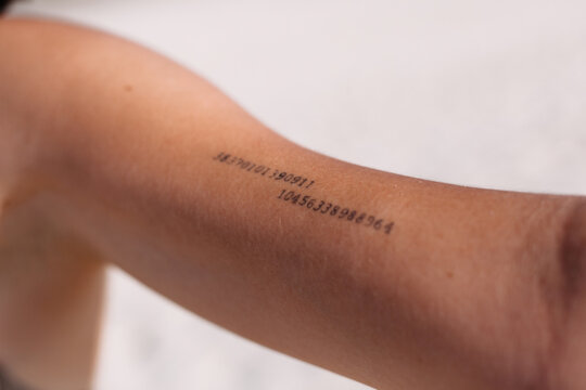 Crop person with tattoo with digits on arm