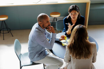 Business people having meeting around table using sticky notes